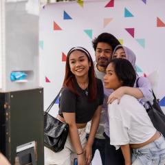 Four international students huddle together for a photo