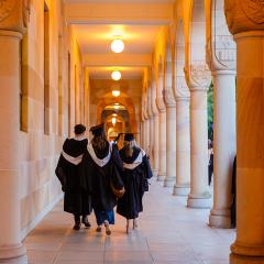Graduating students walking through the Great Court cloisters at The University of Queensland